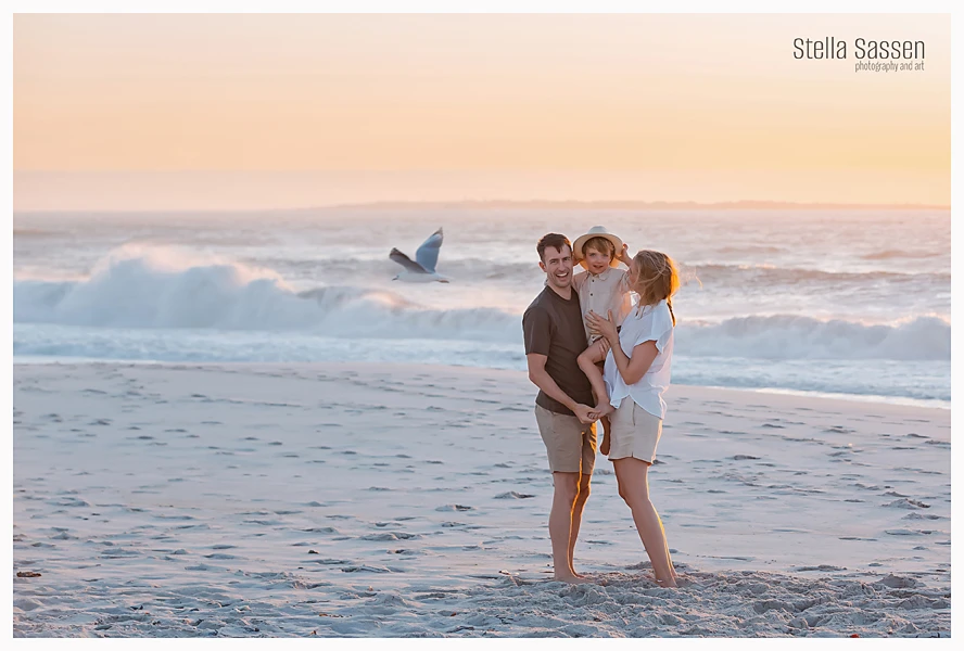 family photo on beach at sunset with gull and sea in background