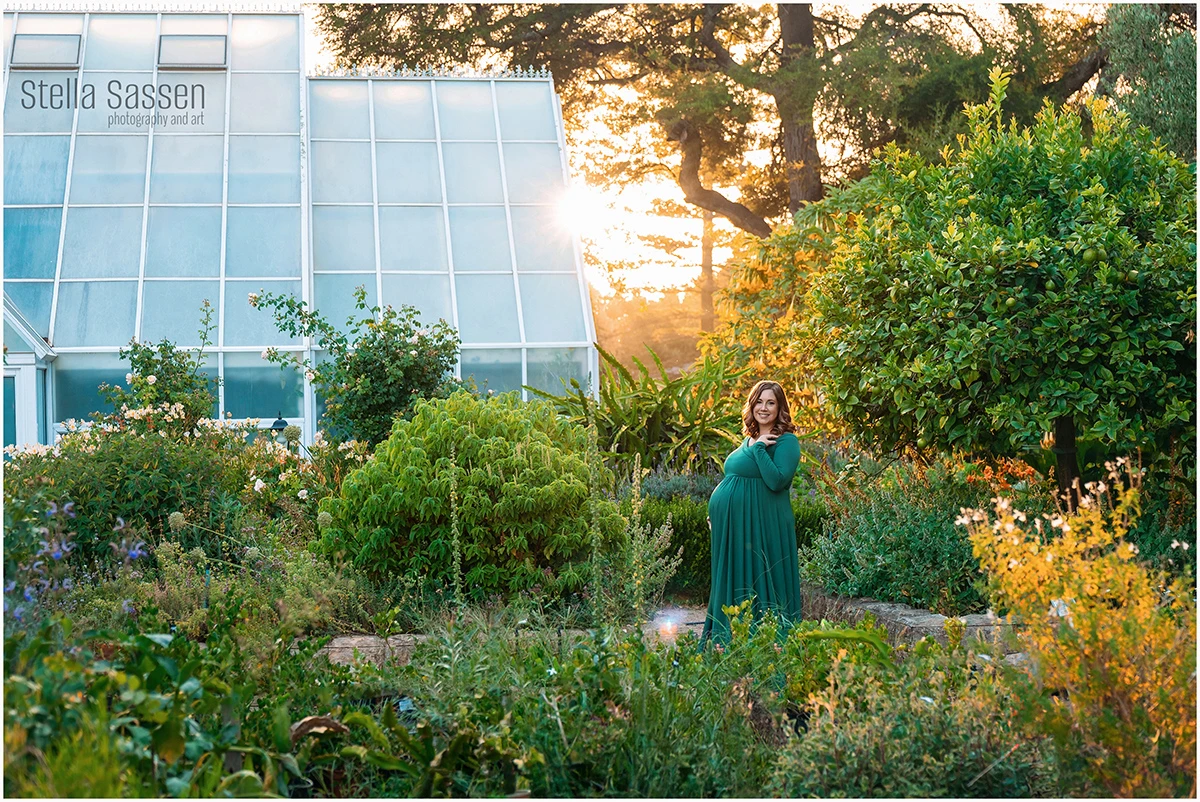 Pregnant woman in emerald green gown standing in lush garden at golden hour, Avondale Gardens Durbanville, maternity photography Cape Town by Stella Sassen