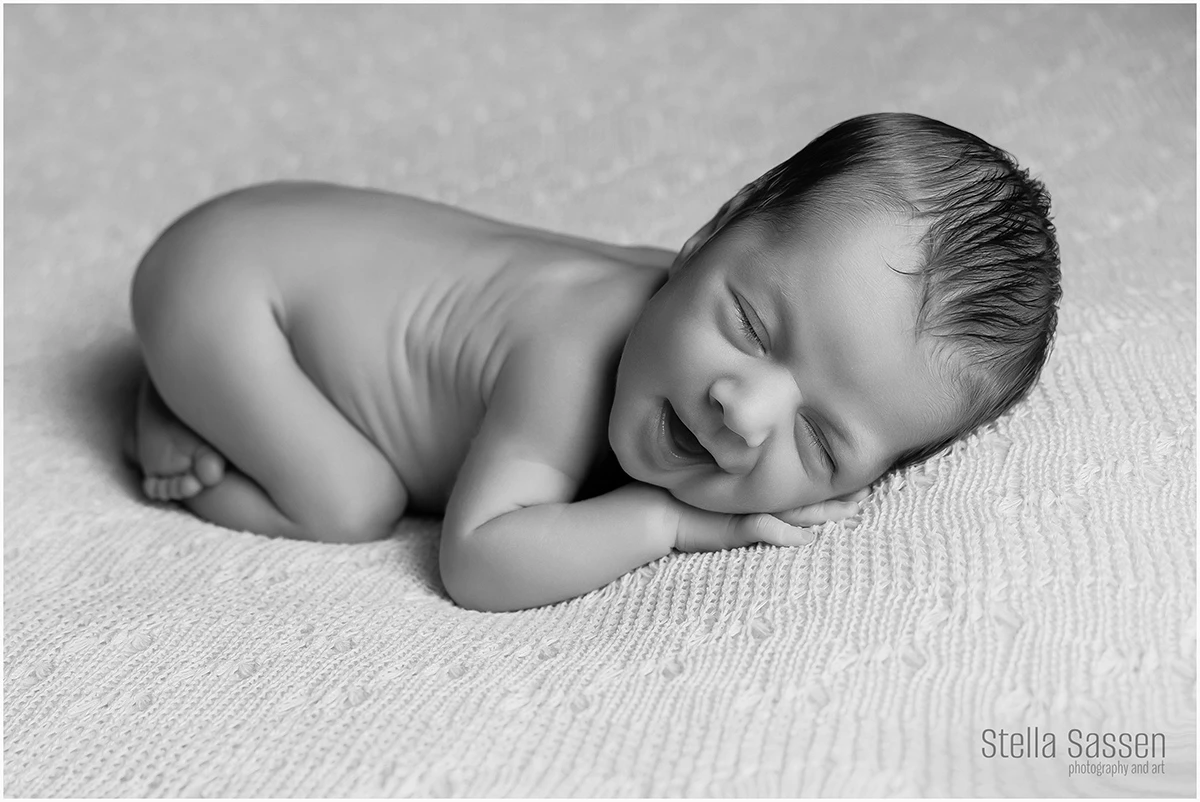 Posed newborn baby boy with a big smile in Cape Town newborn photography studio